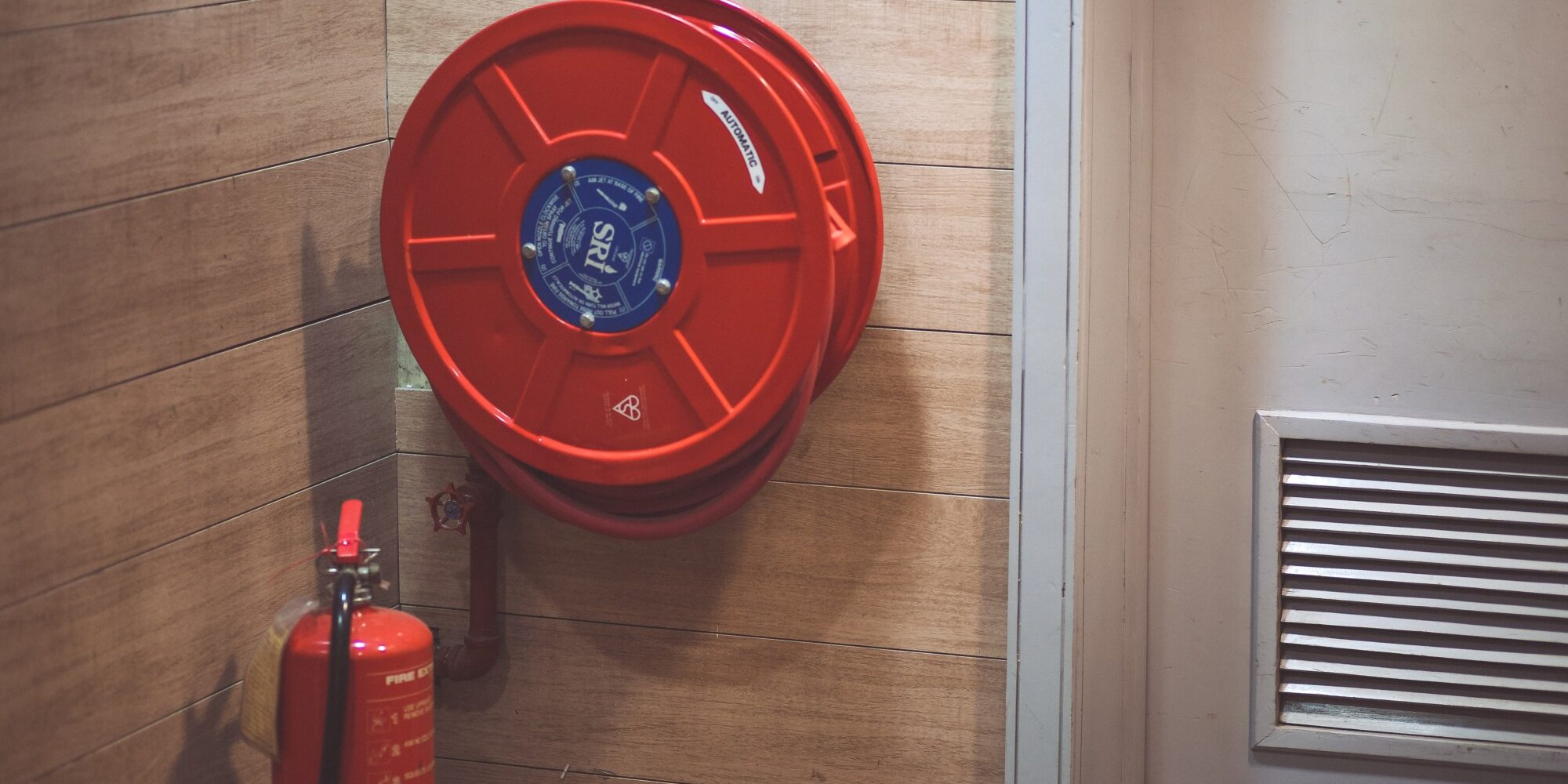 red-fire-extinguisher-beside-hose-reel-inside-the-room-189474